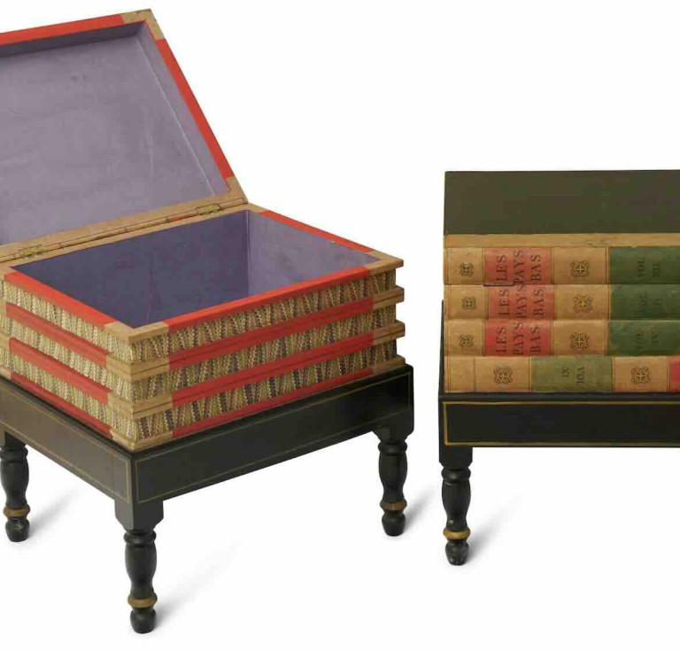 Two library occasional tables of faux books formed as a stack of books on a stand, the spines marked 'LES PAYS BAS' with hinged top lids and marbled paper interiors, on ebonised integral stands, part of the John Laws Collection auction